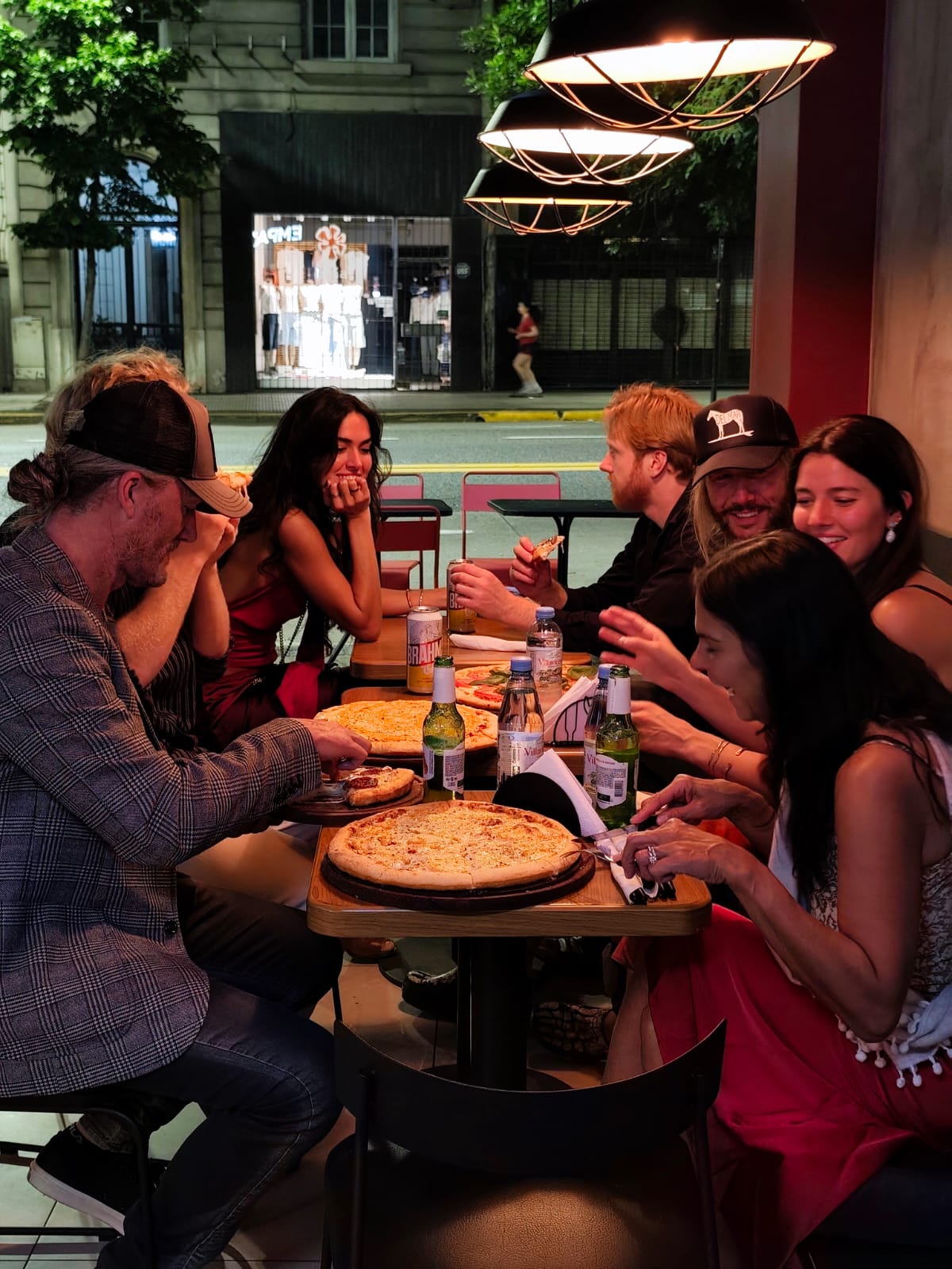 Amigos compartiendo pizzas y empanadas en Empa&rsquo;s World